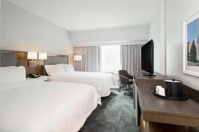 a hotel room with two beds and a desk with a television at Hampton Inn Philadelphia Center City-Convention Center in Philadelphia