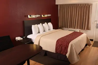 a hotel room with a large bed and a table at Red Roof Inn PLUS+ Philadelphia Airport in Essington