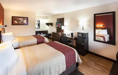 a hotel room with two beds and a mirror at Red Roof Inn PLUS+ Philadelphia Airport in Essington