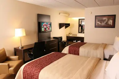 a hotel room with two beds and a desk at Red Roof Inn PLUS+ Philadelphia Airport in Essington