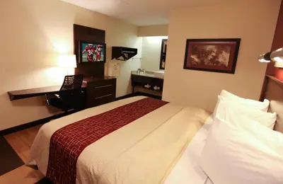 a hotel room with a bed and a desk at Red Roof Inn PLUS+ Philadelphia Airport in Essington
