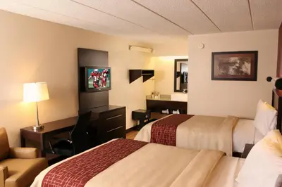 a hotel room with two beds and a desk at Red Roof Inn PLUS+ Philadelphia Airport in Essington