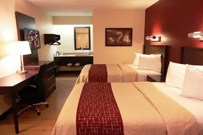 a hotel room with two beds and a desk and a sink at Red Roof Inn PLUS+ Philadelphia Airport in Essington