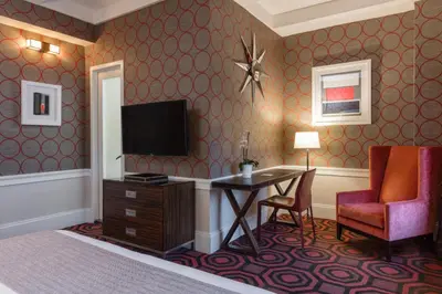 a hotel room with a bed and a desk and a television at The Empire Hotel New York in New York