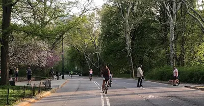 a group of people riding bikes down a street at The Empire Hotel New York in New York