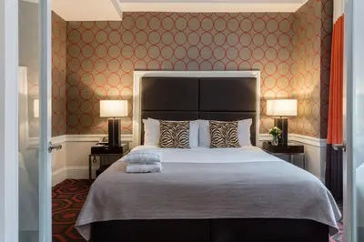 a bedroom with a large bed and two lamps at The Empire Hotel New York in New York