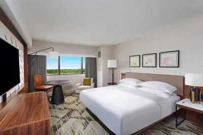 a hotel room with a large bed and a flat screen tv at Sheraton Edison in Edison