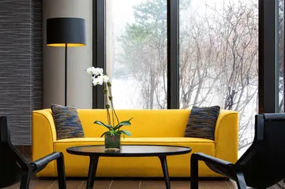 a yellow couch in a living room with a table at Sheraton Edison in Edison
