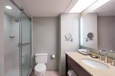 a bathroom with a toilet and a sink and a shower at Sheraton Edison in Edison