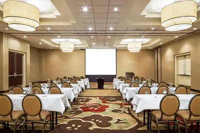 a conference room with tables and chairs and a screen at Sheraton Edison in Edison