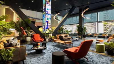 a lobby of a building with chairs and tables at M Social Hotel New York Times Square in New York
