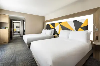 a hotel room with two beds and a kitchen at M Social Hotel New York Times Square in New York
