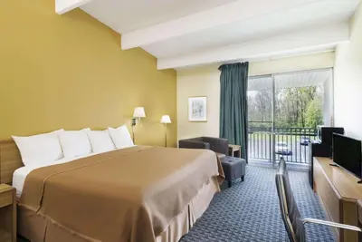 a hotel room with a bed and a balcony at Howard Johnson by Wyndham Newburgh in Newburgh