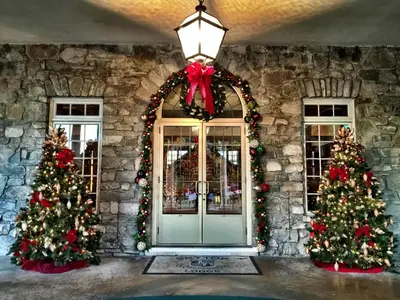 a front door decorated with christmas trees and a red bow at Skytop Lodge in Skytop