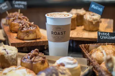 a cup of coffee sitting next to a display of pastries at Skytop Lodge in Skytop