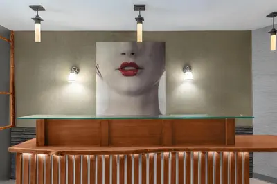 a large painting of a woman with red lips on a wall at Solita Soho Hotel in New York
