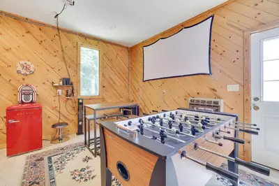 a room with a foosball table and a screen at Mt. Maplewood Lake House in Blakeslee