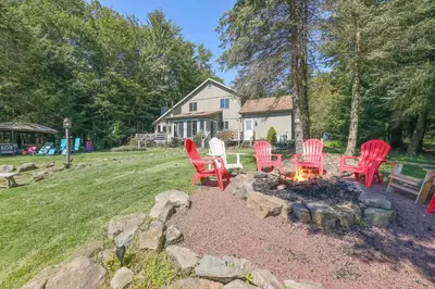 a group of red chairs sitting around a fire pit at Mt. Maplewood Lake House in Blakeslee