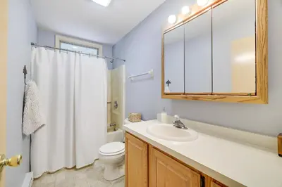 a bathroom with a sink and a toilet and a mirror at Mt. Maplewood Lake House in Blakeslee