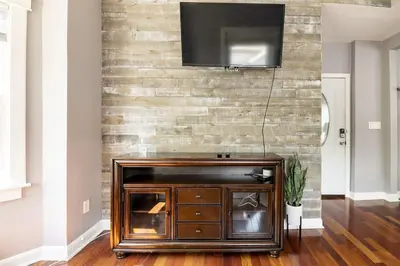 a living room with a television on a brick wall at Riverfront Penthouse Suite in Midtown Harrisburg near Hershey in Harrisburg