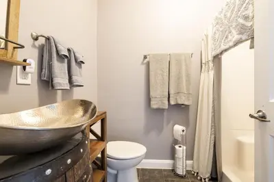 a bathroom with a copper sink and a toilet at Riverfront Penthouse Suite in Midtown Harrisburg near Hershey in Harrisburg