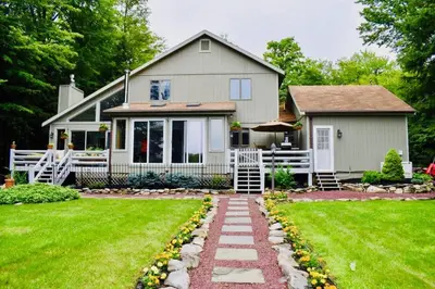 a house with a garden and a walkway at Mt. Maplewood Lake House Apt. in Blakeslee