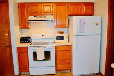a kitchen with a white stove and a refrigerator at Mt. Maplewood Lake House Apt. in Blakeslee