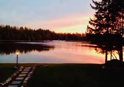 a view of a lake at sunset with a tree at Mt. Maplewood Lake House Apt. in Blakeslee