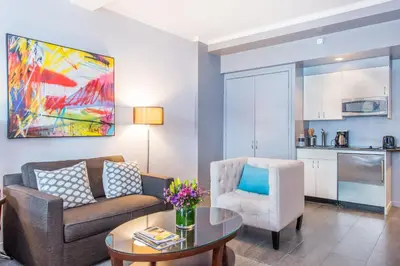 a living room with a couch and a table and a chair at Lombardy Hotel in New York