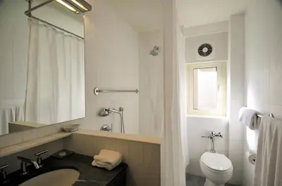 a white bathroom with a sink and a toilet at Lombardy Hotel in New York