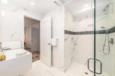 a white bathroom with a shower and a sink at Lombardy Hotel in New York