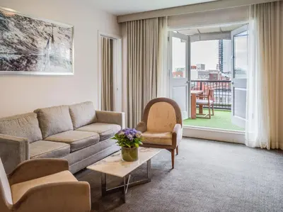 a living room with a couch and chairs and a window at 33 Hotel, New York City, Seaport in New York