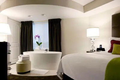 a bedroom with a bed and a tub and a sink at Hyatt House Philadelphia-King of Prussia in King of Prussia