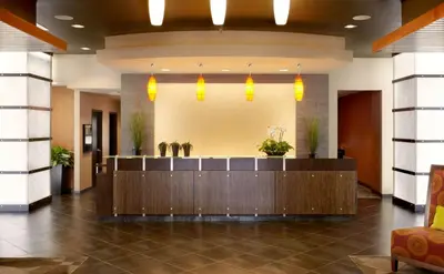 a hotel lobby with a reception desk and potted plants at Hyatt House Philadelphia-King of Prussia in King of Prussia