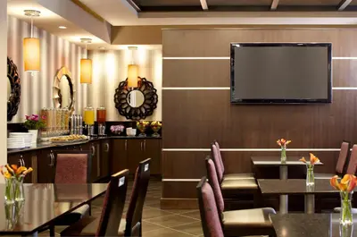 a dining room with a table and a flat screen tv at Hyatt House Philadelphia-King of Prussia in King of Prussia