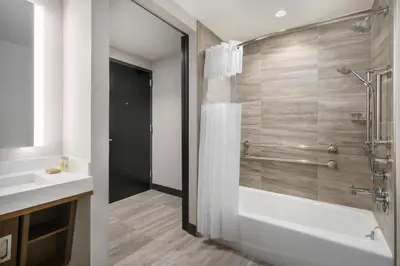 a bathroom with a shower and a tub and a sink at DoubleTree by Hilton New York Times Square South in New York