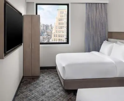 a hotel room with a bed and a large window at DoubleTree by Hilton New York Times Square South in New York