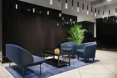 a waiting area with blue chairs and a table at DoubleTree by Hilton New York Times Square South in New York
