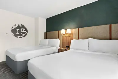 two beds in a hotel room with white sheets at Holiday Inn Manhattan 6th Ave - Chelsea by IHG in New York