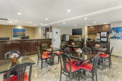 a restaurant with tables and chairs and a bar at Best Western Fort Lee in Fort Lee