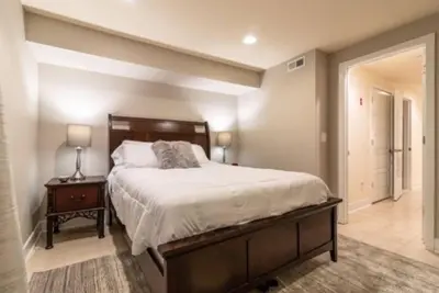 a bedroom with a large bed and a lamp on a table at Beautiful Lux 4 Bedroom*Near PENN/CHOP*Roof Deck in Philadelphia