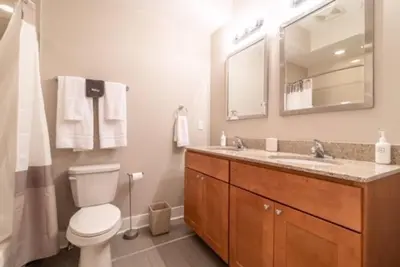a bathroom with a toilet and a sink and a mirror at Beautiful Lux 4 Bedroom*Near PENN/CHOP*Roof Deck in Philadelphia