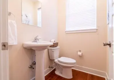 a white bathroom with a toilet and a sink at Beautiful Lux 4 Bedroom*Near PENN/CHOP*Roof Deck in Philadelphia