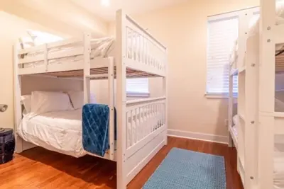 a bedroom with two bunk beds and a window at Beautiful Lux 4 Bedroom*Near PENN/CHOP*Roof Deck in Philadelphia
