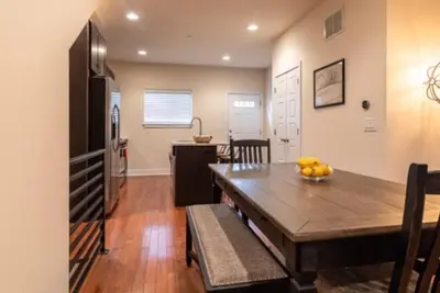 a kitchen and dining room with a wooden table at Beautiful Lux 4 Bedroom*Near PENN/CHOP*Roof Deck in Philadelphia