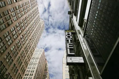 a sign for a hotel in the middle of tall buildings at Doxie Hotel in New York