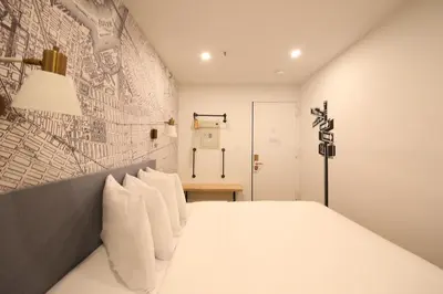 a bedroom with a white bed with a wall at Doxie Hotel in New York