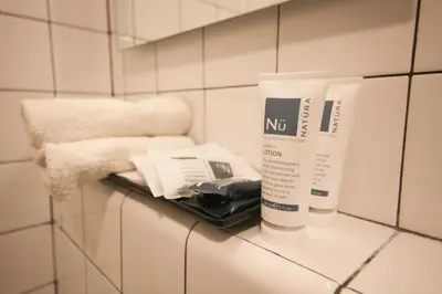 a shelf in a bathroom with two products on it at Doxie Hotel in New York