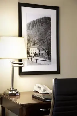 a desk with a lamp and a phone on it at Clinton Inn Hotel Tenafly in Tenafly