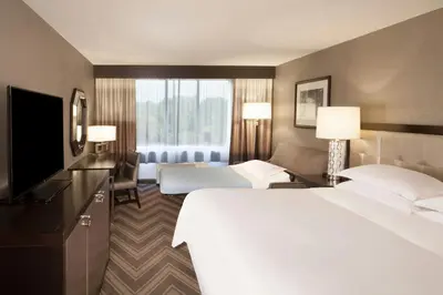 a hotel room with a large bed and a television at Sheraton Bucks County Langhorne in Langhorne